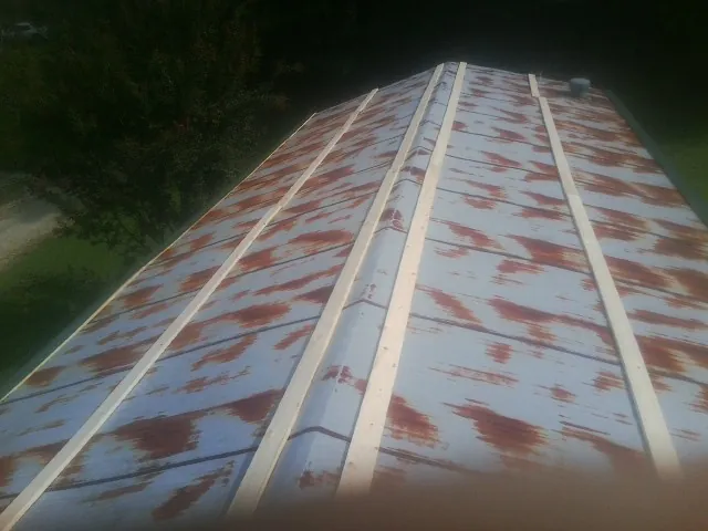 Rusted metal roof panels with new wood purlins before replacement — Storm Damage Roof Repair in Locust by Roofing Brothers