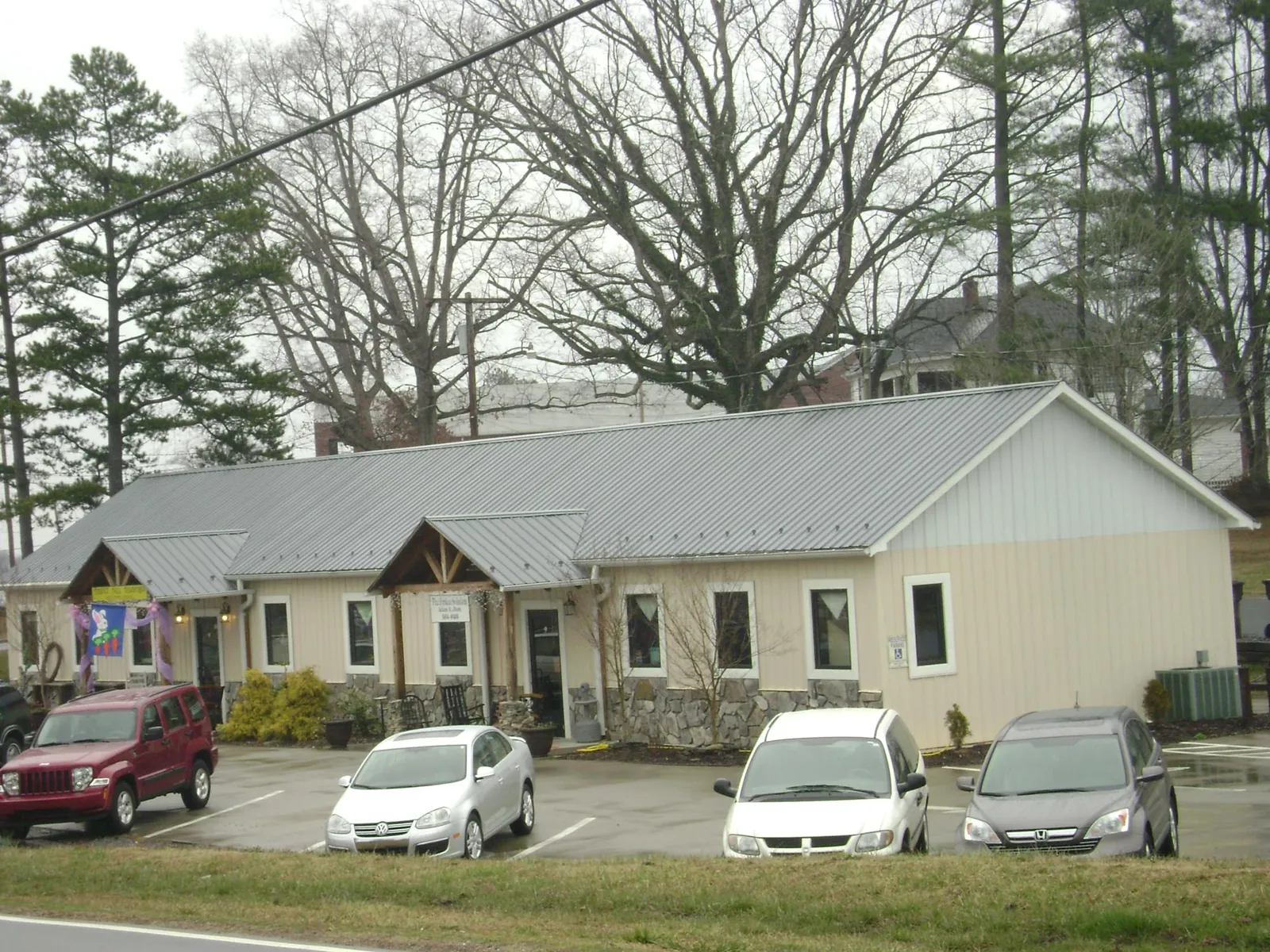 Gray metal roof with timber entry brackets on a small commercial building in Locust