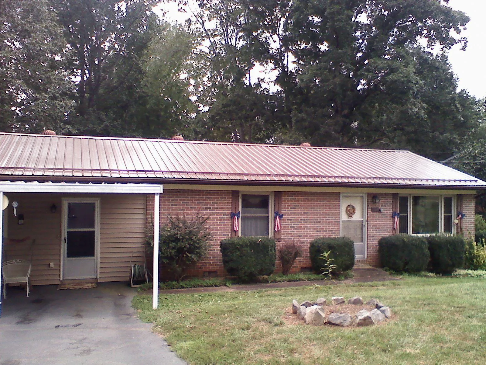Bronze metal roof and carport on a brick ranch home — Roof Repair work by our crew in Locust