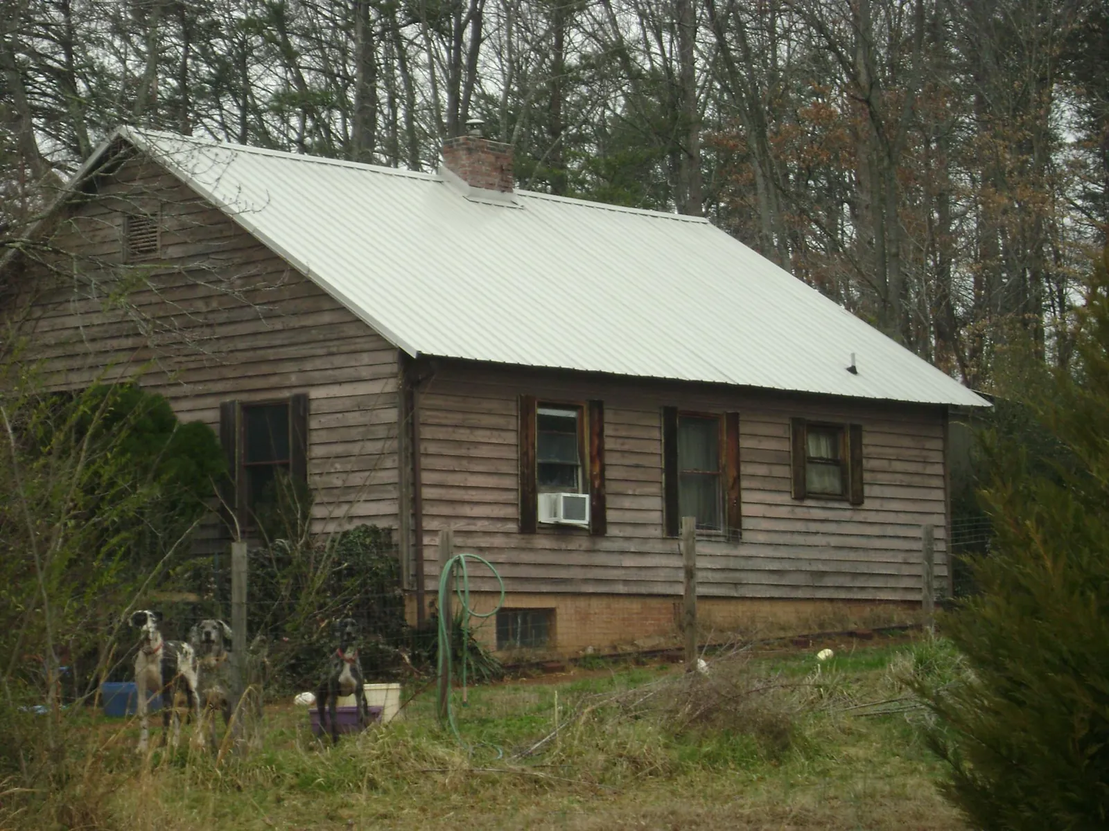White metal roof on an old wood sided farmhouse, from a Metal Roof Installation job in Locust